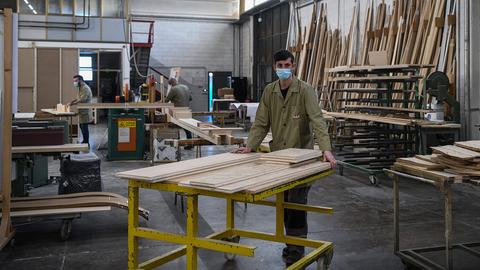 Drei Männer arbeiten in einer Möbelwerkstatt. (AFP)