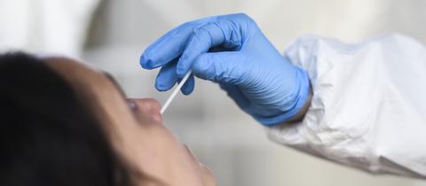 Eine Mitarbeiterin eines Testzentrums nimmt einen Nasenabstrich für einen Corona-Schnelltest.  (dpa)