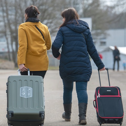 Drei aus der Ukraine stammende Frauen gehen in der Landeserstaufnahmestelle für Flüchtlinge (LEA) zu ihrem Quartier.  (dpa)