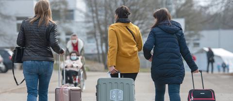 Drei aus der Ukraine stammende Frauen gehen in der Landeserstaufnahmestelle für Flüchtlinge (LEA) zu ihrem Quartier.  (dpa)