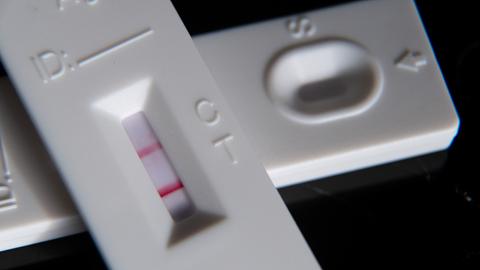 Ein positiver Corona-Schnelltest liegt auf einem weiteren Schnelltest. (dpa)