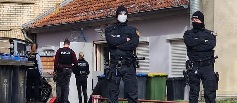 Polizisten stehen vor einem Hintereingang eines Gebäudes in Eisenach. (dpa)