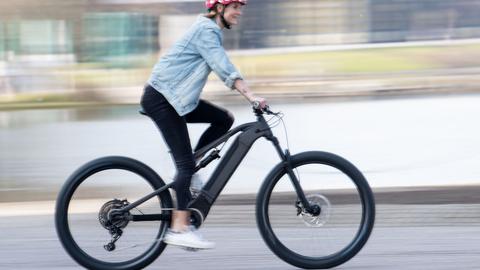 Eine Frau fährt auf einem Elektrofahrrad auf dem Gelände von der Fahrrad-Messe in Essen. (dpa)