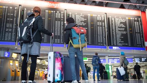 Menschen stehen am Flughafen Frankfurt vor der Anzeigetafel für Abflüge (dpa)