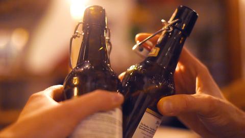 Zwei Menschen stoßen mit Bier in der Flasche an. (dpa)