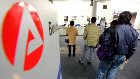 Menschen stehen  in einem Jobcenter der Bundesagentur für Arbeit in einer Schlange.  (picture alliance / ASSOCIATED PR)