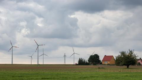 Windräder drehen sich hinter einem Dorf in Sachsen-Anhalt (Archivbild September 2021). (dpa)