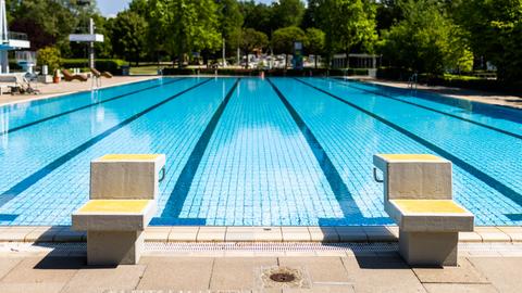 Absprungblöcke stehen in einem Freibad am Rand des leeren Beckens. (dpa)