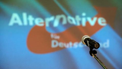 Ein Mikrofon steht beim Landesparteitag der sächsischen AfD auf der Bühne vor dem Partei-Logo. (picture alliance/dpa/dpa-Zentral)