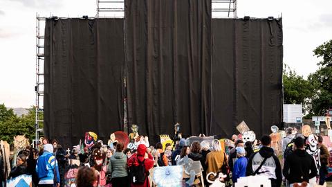 Menschen stehen vor dem abgehängten umstrittenen Banner auf der documenta in Kassel  (AFP)
