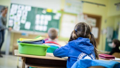 Schülerinnen und Schüler einer Grundschule sitzen mit Abstand in ihrem Klassenraum. (dpa)