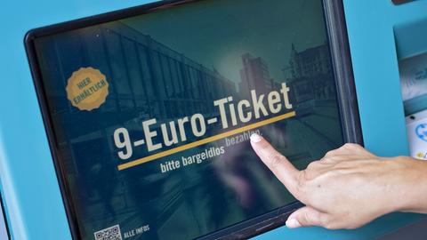 Eine Frau zieht in Frankfurt am Main an einem Fahrschein-Automaten ein 9-Euro-Ticket (dpa)