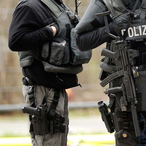 SEK-Beamte mit Maschinenpistolen bei einem Einsatz - die Gesichter sind nicht zu sehen. (dpa)