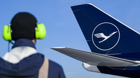 Ein Flughafenmitarbeiter steht vor einem Flugzeug der Lufthansa. (dpa)