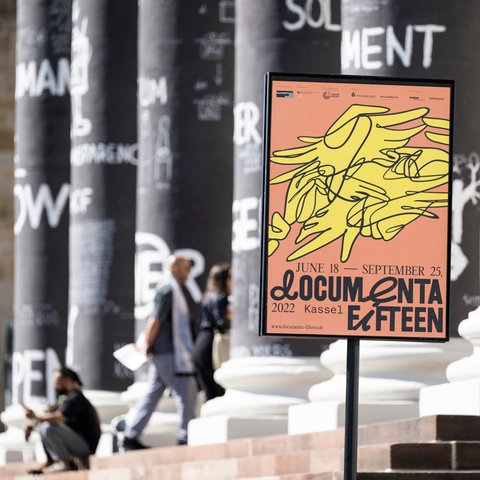 Ein Plakat der documenta in einem Plakatständer vor den Säulen des Museums Fridericianum. (picture alliance/dpa)
