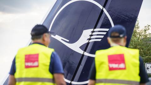 Zwei Lufthansa-Mitarbeiter in ver.di-Warnweste vor einem Flugzeug (dpa)