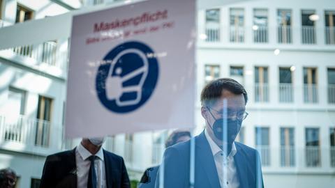 Karl Lauterbach (SPD), Bundesminister für Gesundheit, geht auf dem Weg zur Pressekonferenz zur Corona-Lage an einem Hinweisschild auf die Maskenpflicht in der Bundespressekonferenz vorbei.  (dpa)