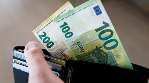 Aus einem Geldbeutel stehen 300 Euro in Bargeld heraus. (picture alliance / Fotostand)