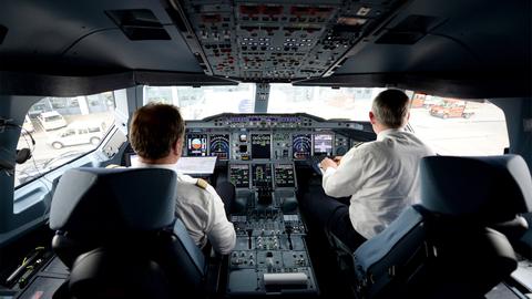 Zwei Piloten arbeiten auf dem Flughafen in Hamburg im Cockpit eines Lufthansa-Airbus A380 (dpa)