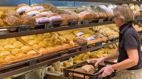 Bäckereifachverkäuferin legt Brot in die Auslage (picture alliance/dpa)