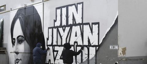 Künstler arbeiten in Frankfurt am Main an der Fertigstellung eines Wandgemäldes für die im Iran zu Tode gekommene Mahsa Amini. (dpa)