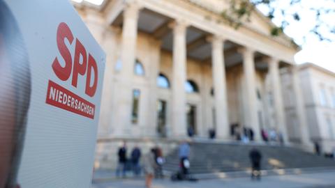 Auf der Ecke eines Wahlplakates ist "SPD Niedersachsen" zu lesen, im Hintergrund verschwommen der Landtag in Hannover. (dpa)