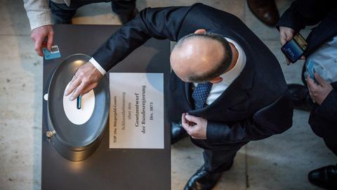 Bundeskanzler Olaf Scholz (SPD) wirft seine Stimmkarte zum Bürgergeld im Bundestag ein. (dpa)