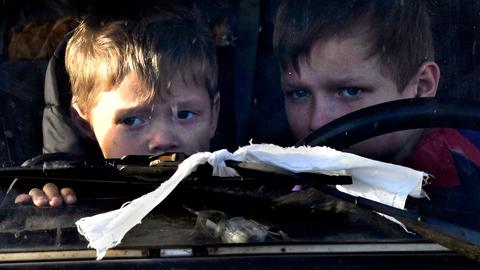 Kinder blicken durch die Windschutzscheibe eines Autos in der Ukraine.  (picture alliance/dpa/ZUMA Press )