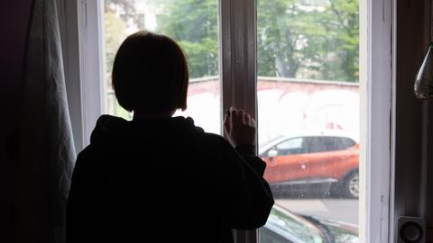  Eine Jugendliche blickt aus einem Fenster. (dpa)