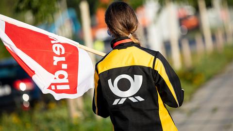 Eine Beschäftigte der Deutschen Post mit einer Fahne der Gewerkschaft Verdi. (picture alliance/dpa)