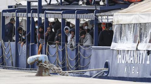 Migranten stehen an Deck der "Humanity 1" im Hafen von Catania (Archivbild) (dpa)