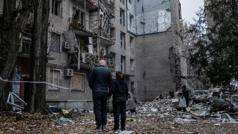 Zwei Anwohner stehen vor den Trümmern eines Gebäudes in Mykolajiw (Ukraine). (dpa)