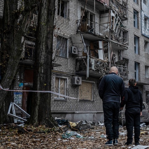 Zwei Anwohner stehen vor den Trümmern eines Gebäudes in Mykolajiw (Ukraine). (dpa)