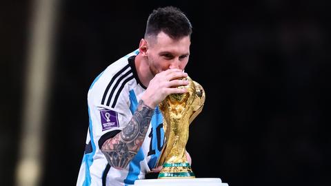 Lionel Messi küsst in Katar den WM-Pokal (dpa)
