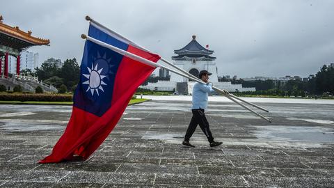 in Mann trägt Taiwan-Flaggen auf dem Freiheitsplatz vor dem Chiang Kai-shek-Mausoleum in Taipeh. (dpa)