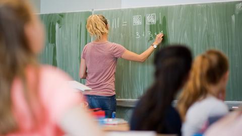 Eine Lehrerin schreibt im Mathematikunterricht einer achten Klasse an eine Schultafel. (dpa)