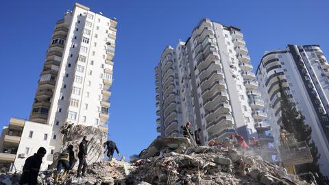 Notfallteams suchen nach Menschen in den Trümmern eines zerstörten Gebäudes in Adana (dpa)