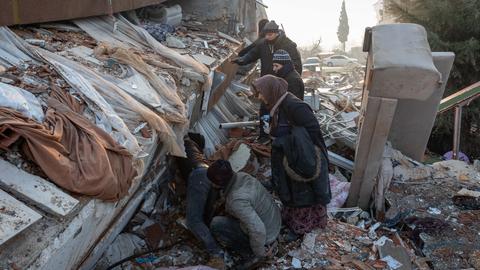 Menschen sind in Antakya in der Türkei auf der Suche nach Überlebenden in Trümmern. (dpa)