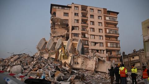 Sicherheitskräfte vor einem zerstörten Gebäude nach schweren Erdbeben in Syrien und der Türkei (dpa)