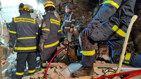 Einsatzkräfte des Technischen Hilfswerks (THW) stehen in den Trümmern eines eingestürzten Gebäudes. (dpa)