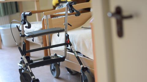 Ein Rollator steht in einem Seniorenheim in einem Zimmer neben einem Pflegebett. (picture alliance / ZB)