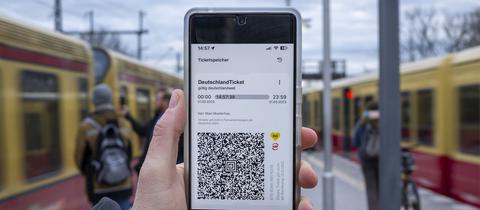 Auf dem Display eines Smartphones wird der QR-Code vom bundesweiten Deutschland-Ticket angezeigt. (picture alliance/dpa)