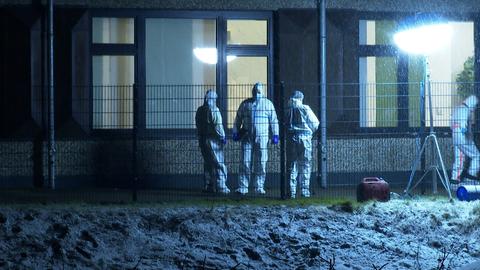 Einsatzkräfte der Polizei stehen in weißen Ganzkörper-Schutzanzügen vor dem Gebäude in Hamburg-Alsterdorf, in welchem sich ein mutmaßlicher Amoklauf ereignet hat. (dpa)