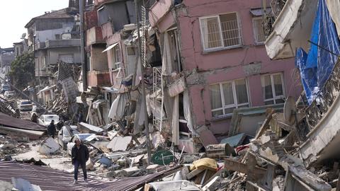 Ein Mann läuft an vom Erdbeben zerstörten Häusern in Hatay (Türkei) vorbei. (dpa)