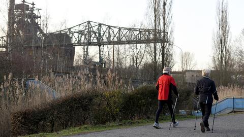 Ein Ehepaar walkt am frühen Morgen an den alten Hochöfen im Landschaftspark Duisburg Nord vorbei. (picture alliance/dpa)