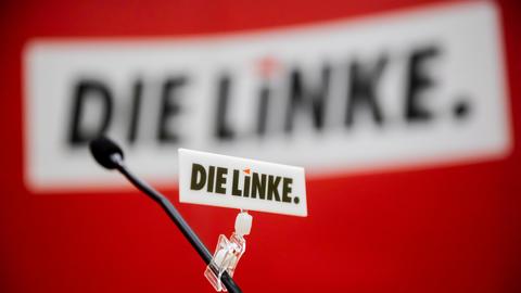 Logo der Partei Die Linke ist auf einem Schild an einem Mikrofon zu sehen (dpa)