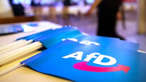 Fähnchen mit dem Logo der AfD liegen auf einem Tisch.  (picture alliance/dpa)