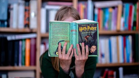 Eine junge Frau liest das Buch "Harry Potter und der Orden des Phoenix"  (picture alliance / ZB)