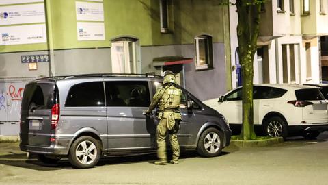 Ein Polizist steht vor einem Einsatzfahrzeug während einer Razzia gegen die 'Ndrangheta in Hagen. 