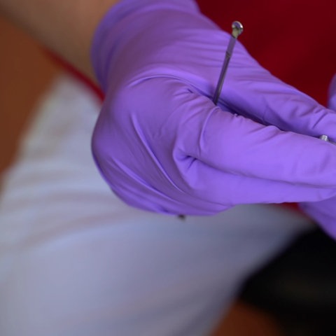 Hände halten ein Proberöhrchen in einem Labor.